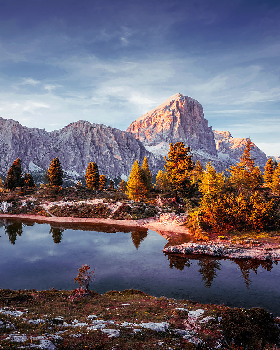 Golden-hour light reflected on Lago di Limides with Dolomite peaks in the background