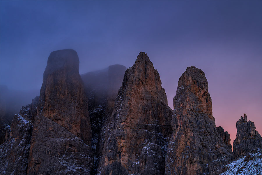 Misty early morning light softening the rugged peaks of Sella Pass in the Dolomites.