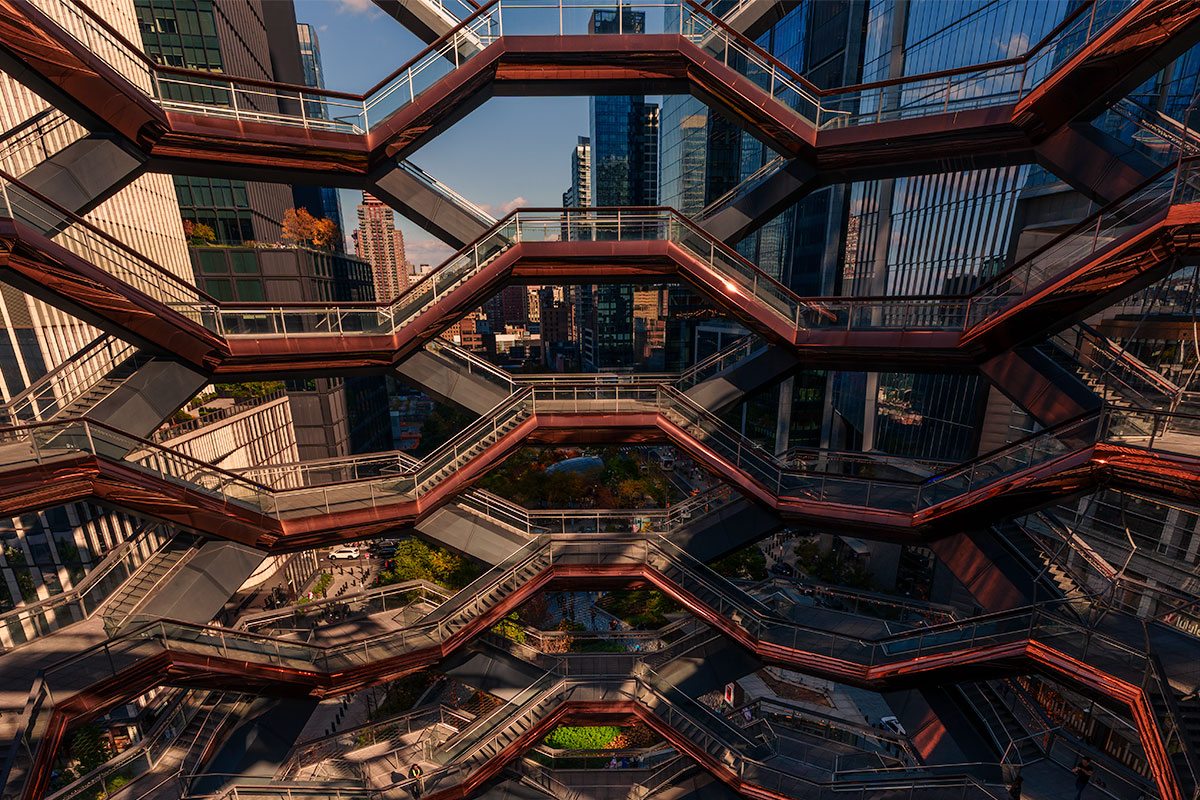 Geometric staircases of the Vessel at Hudson Yards framed by the New York City skyline